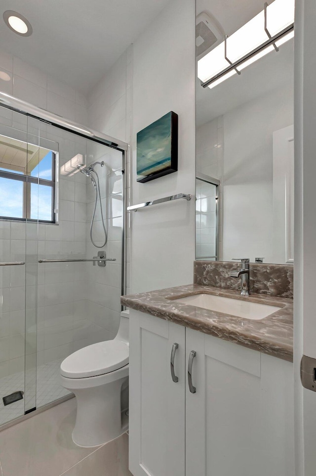 bathroom featuring tile patterned floors, vanity, an enclosed shower, and toilet