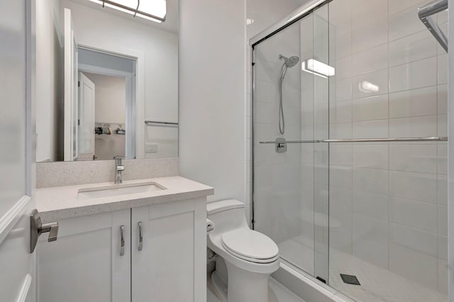 bathroom with vanity, toilet, and a shower with shower door