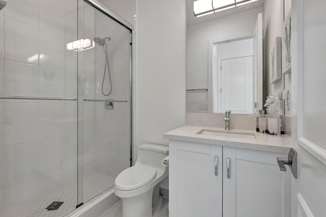 bathroom with vanity, a shower with shower door, and toilet