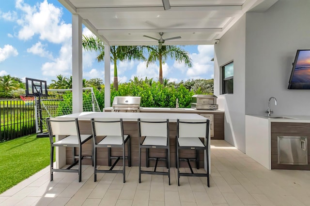 view of patio / terrace featuring exterior kitchen, area for grilling, a wet bar, and ceiling fan