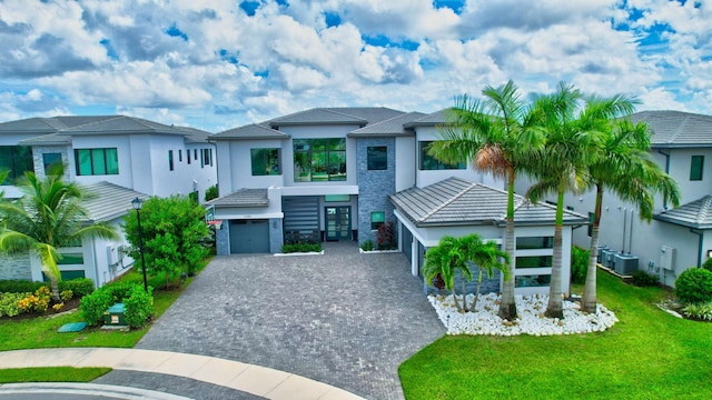 view of front of house featuring a front yard and central AC unit