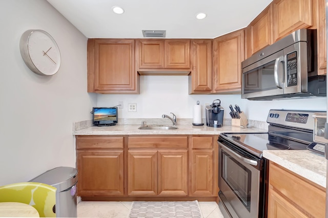 kitchen with light tile patterned floors, stainless steel appliances, and sink