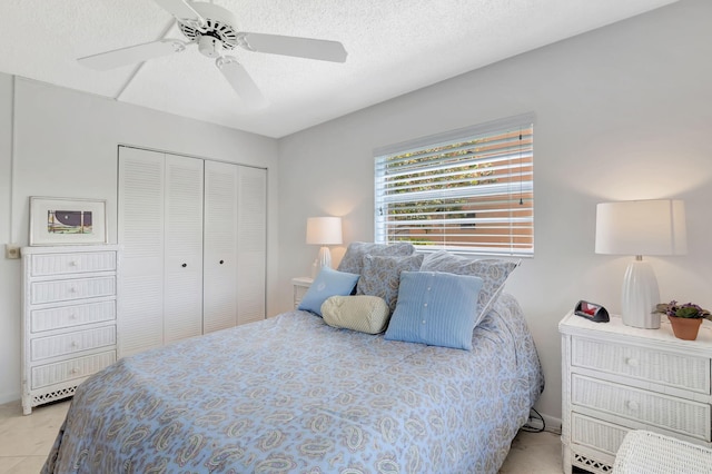 tiled bedroom with a closet, ceiling fan, and a textured ceiling