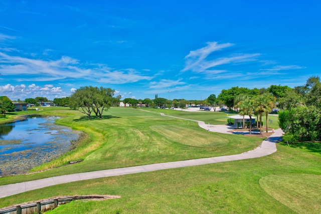 view of property's community featuring a lawn and a water view