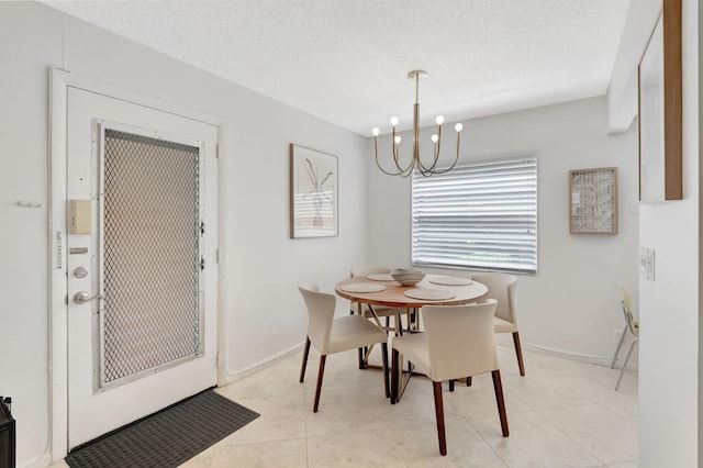 dining area featuring a notable chandelier, light tile patterned floors, and a textured ceiling