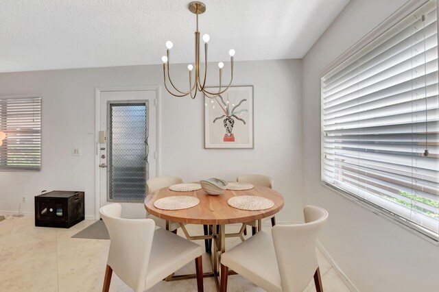 dining area with a chandelier, a textured ceiling, plenty of natural light, and tile patterned floors