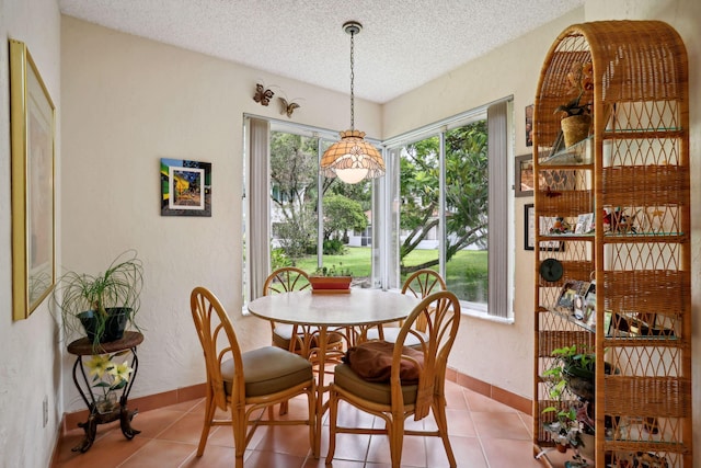 tiled dining space with a textured ceiling