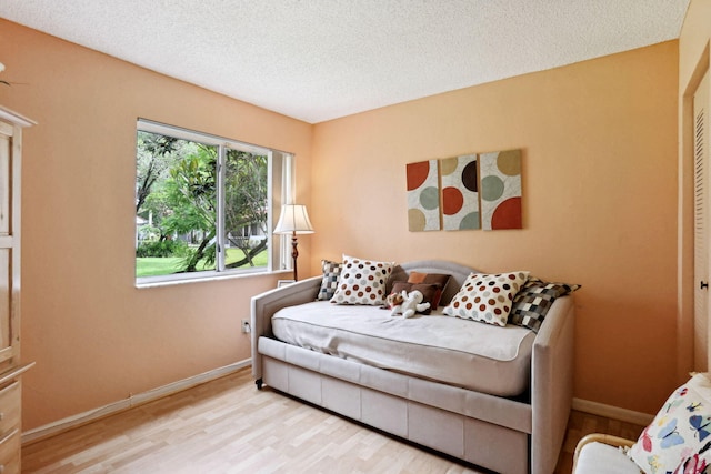 living room featuring a textured ceiling and light hardwood / wood-style floors