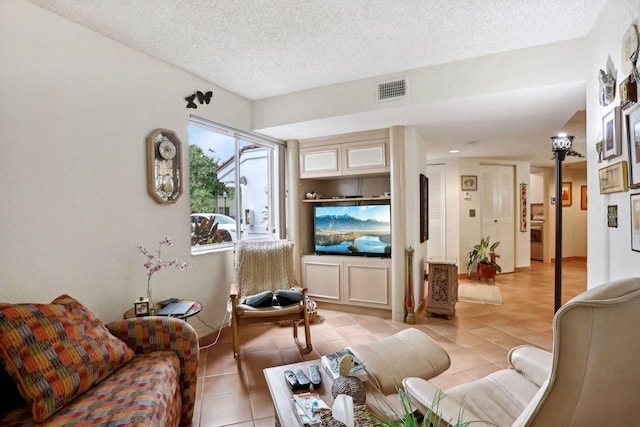 living room featuring a textured ceiling and light tile patterned flooring