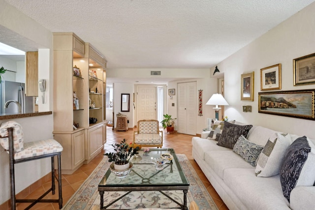 tiled living room featuring a textured ceiling