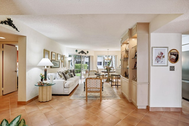 living room featuring a textured ceiling, a chandelier, and light tile patterned flooring