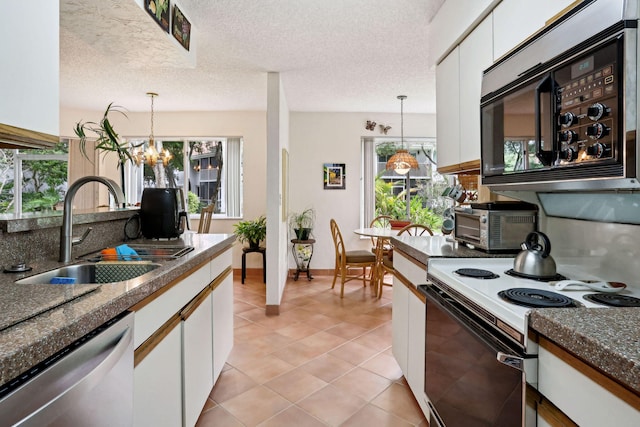 kitchen featuring appliances with stainless steel finishes, white cabinetry, a textured ceiling, decorative light fixtures, and a notable chandelier