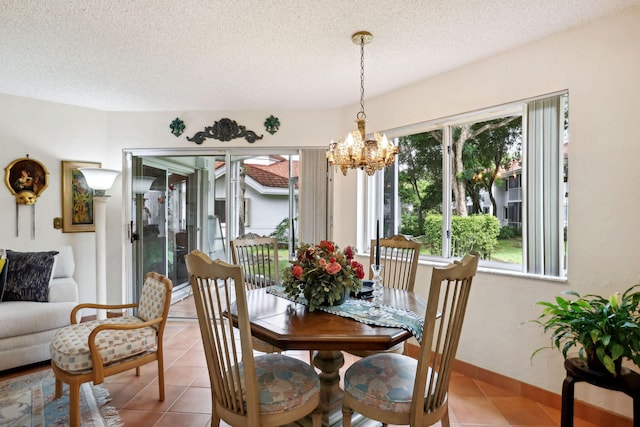 tiled dining room with a chandelier, a textured ceiling, and plenty of natural light