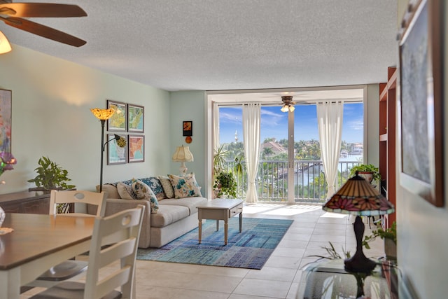 living room featuring a textured ceiling, light tile patterned floors, and a healthy amount of sunlight