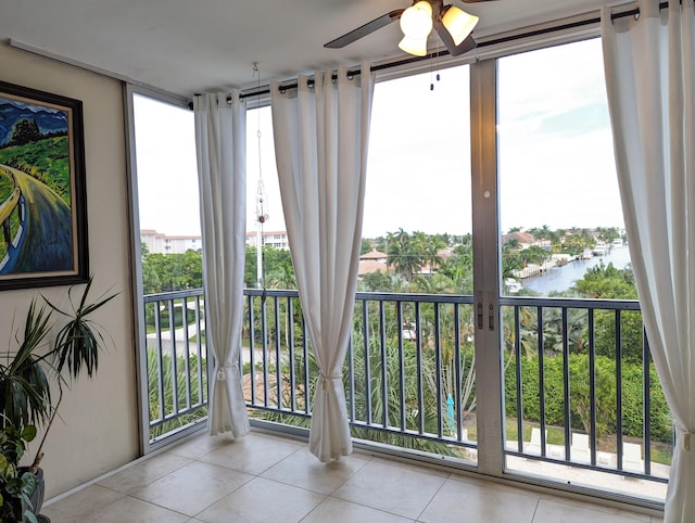 sunroom with a water view and ceiling fan