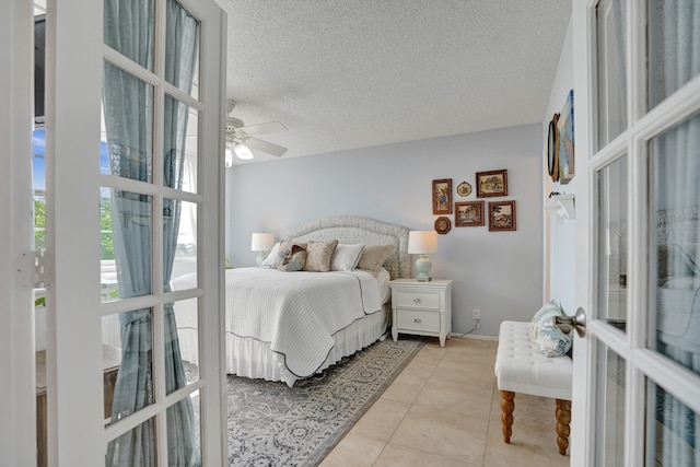 bedroom with ceiling fan, a textured ceiling, light tile patterned floors, and french doors