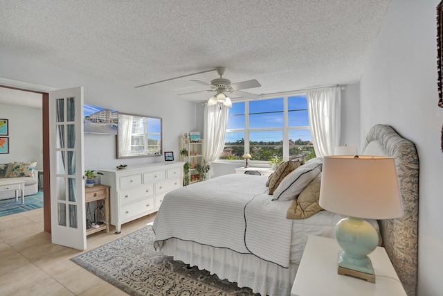 bedroom featuring light tile patterned flooring, a textured ceiling, and ceiling fan