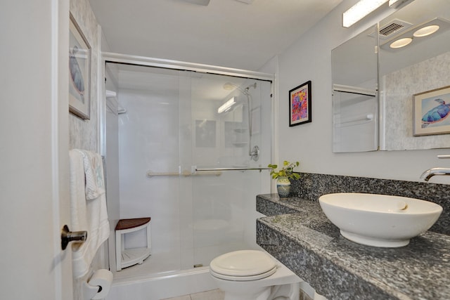 bathroom featuring toilet, sink, tile patterned floors, and a shower with shower door