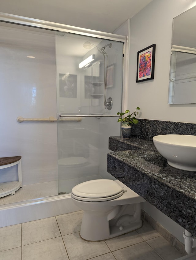 bathroom featuring a shower with door, tile patterned floors, toilet, and sink