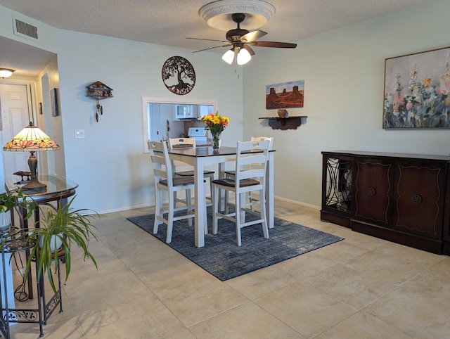 dining room featuring light tile patterned flooring, a textured ceiling, and ceiling fan