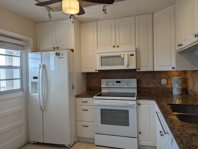 kitchen with white cabinetry, ceiling fan, dark stone countertops, light tile patterned floors, and white appliances