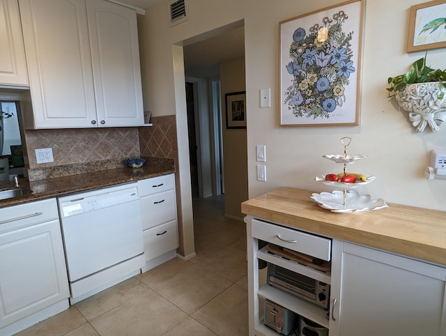 kitchen with white cabinetry, butcher block countertops, dishwasher, and tasteful backsplash