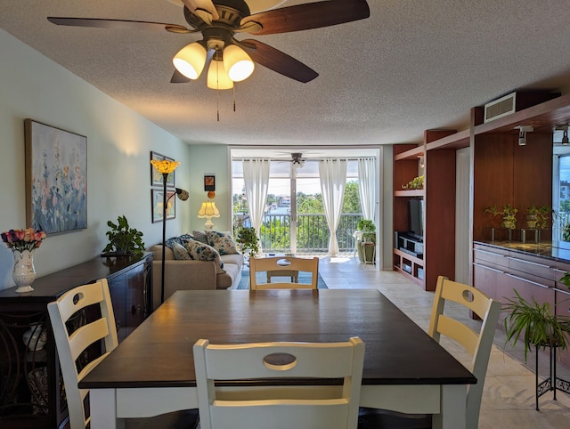 dining space with light tile patterned flooring, ceiling fan, and a textured ceiling