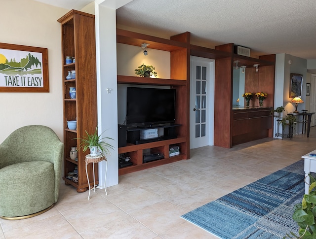 tiled living room featuring a textured ceiling