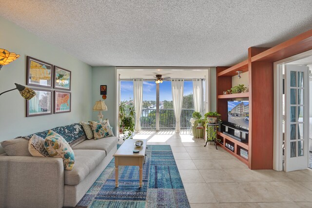 living room with expansive windows, ceiling fan, a textured ceiling, and light tile patterned floors