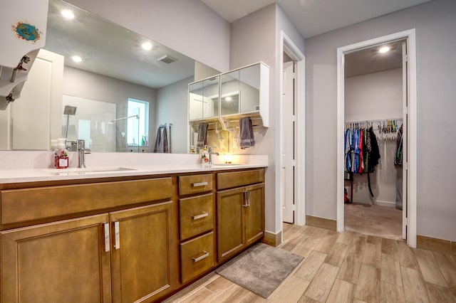 bathroom featuring a shower with door, hardwood / wood-style flooring, and vanity