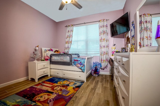 bedroom featuring ceiling fan, light hardwood / wood-style flooring, and multiple windows