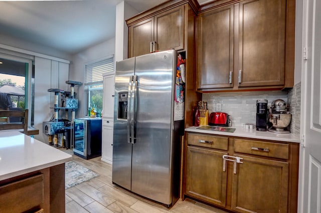 kitchen featuring stainless steel fridge, wine cooler, backsplash, and light hardwood / wood-style flooring