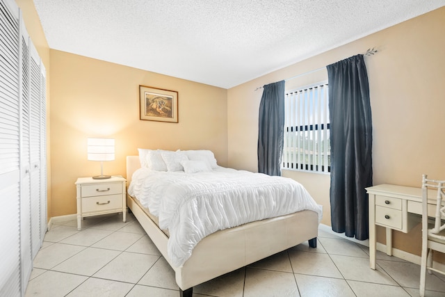 tiled bedroom featuring a textured ceiling