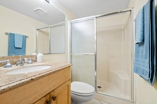 bathroom with vanity, toilet, tile patterned floors, and a shower with shower door