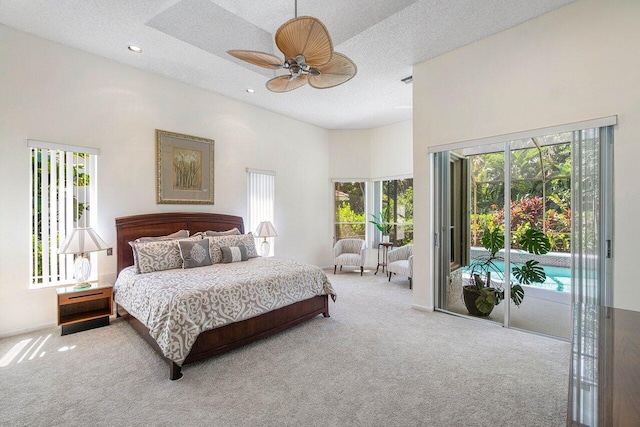 carpeted bedroom featuring a towering ceiling, a textured ceiling, access to exterior, and ceiling fan