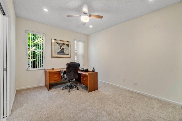 office with a textured ceiling, light colored carpet, and ceiling fan