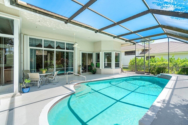 view of swimming pool with a patio area and glass enclosure