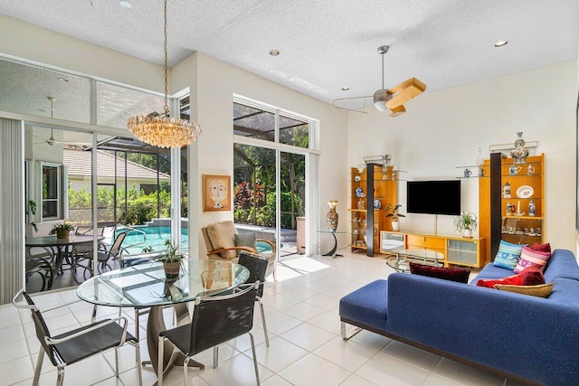 tiled dining space featuring a textured ceiling and ceiling fan with notable chandelier