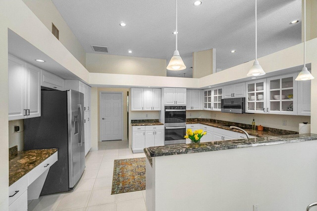 kitchen with kitchen peninsula, white cabinets, decorative light fixtures, and stainless steel appliances