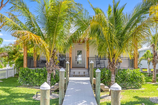 doorway to property with a lawn and covered porch