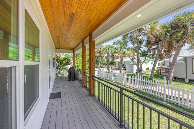 wooden terrace with a yard and a porch