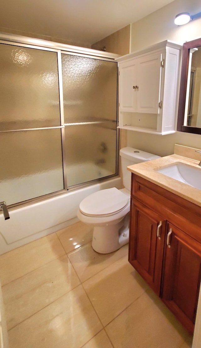 full bathroom featuring tile patterned flooring, combined bath / shower with glass door, vanity, and toilet