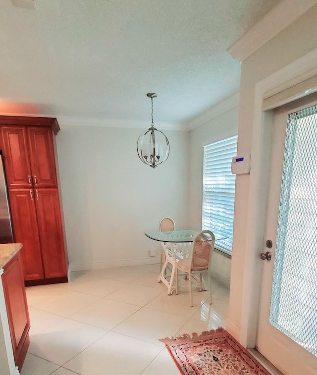 tiled dining room featuring ornamental molding and an inviting chandelier