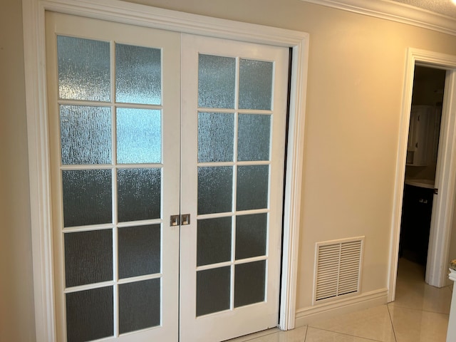 doorway featuring crown molding, light tile patterned floors, and french doors