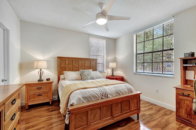 630 S Sapodilla Ave Unit 216, West Palm Beach, FL 33401 - bedroom featuring a textured ceiling, light wood-style flooring, baseboards, and a ceiling fan