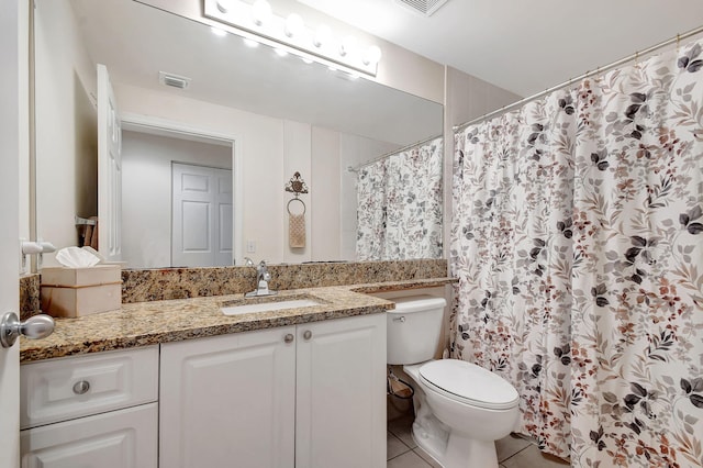 bathroom with tile patterned flooring, vanity, and toilet