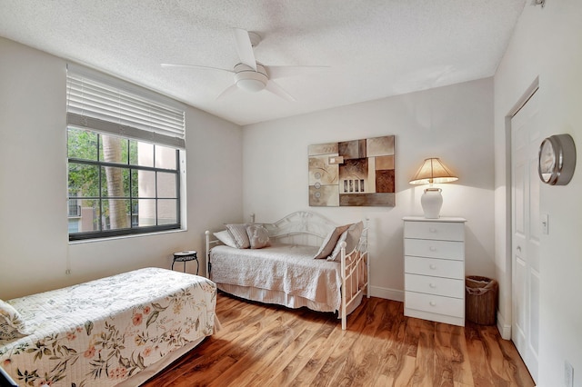 bedroom featuring a textured ceiling, wood-type flooring, and ceiling fan