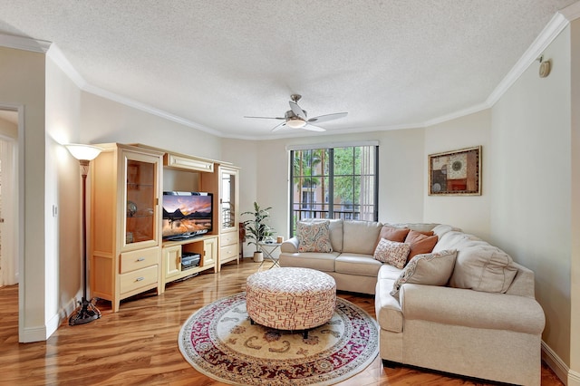 living room featuring hardwood / wood-style flooring, ceiling fan, crown molding, and a textured ceiling