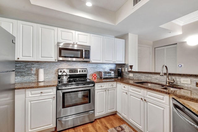 630 S Sapodilla Ave Unit 216, West Palm Beach, FL 33401 - kitchen featuring stainless steel appliances, a sink, backsplash, white cabinets, and crown molding