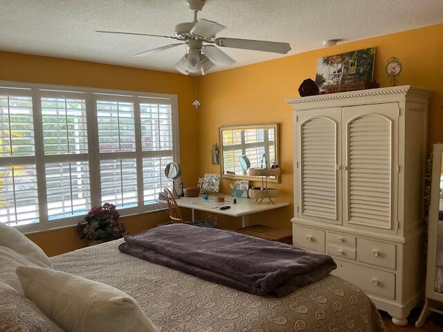 bedroom with a textured ceiling and ceiling fan